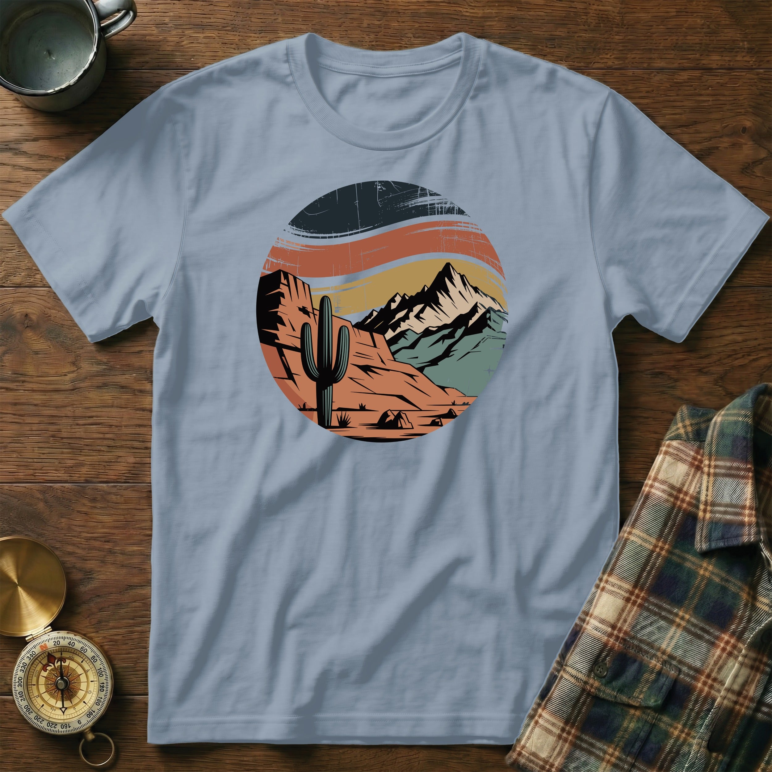 T-shirt design with desert landscape, mountains, cactus, and vintage sunset.