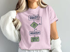 Pink t-shirt with flowchart graphic: Coast, Too Hot?, Yes, Mountain, Problem Solved.