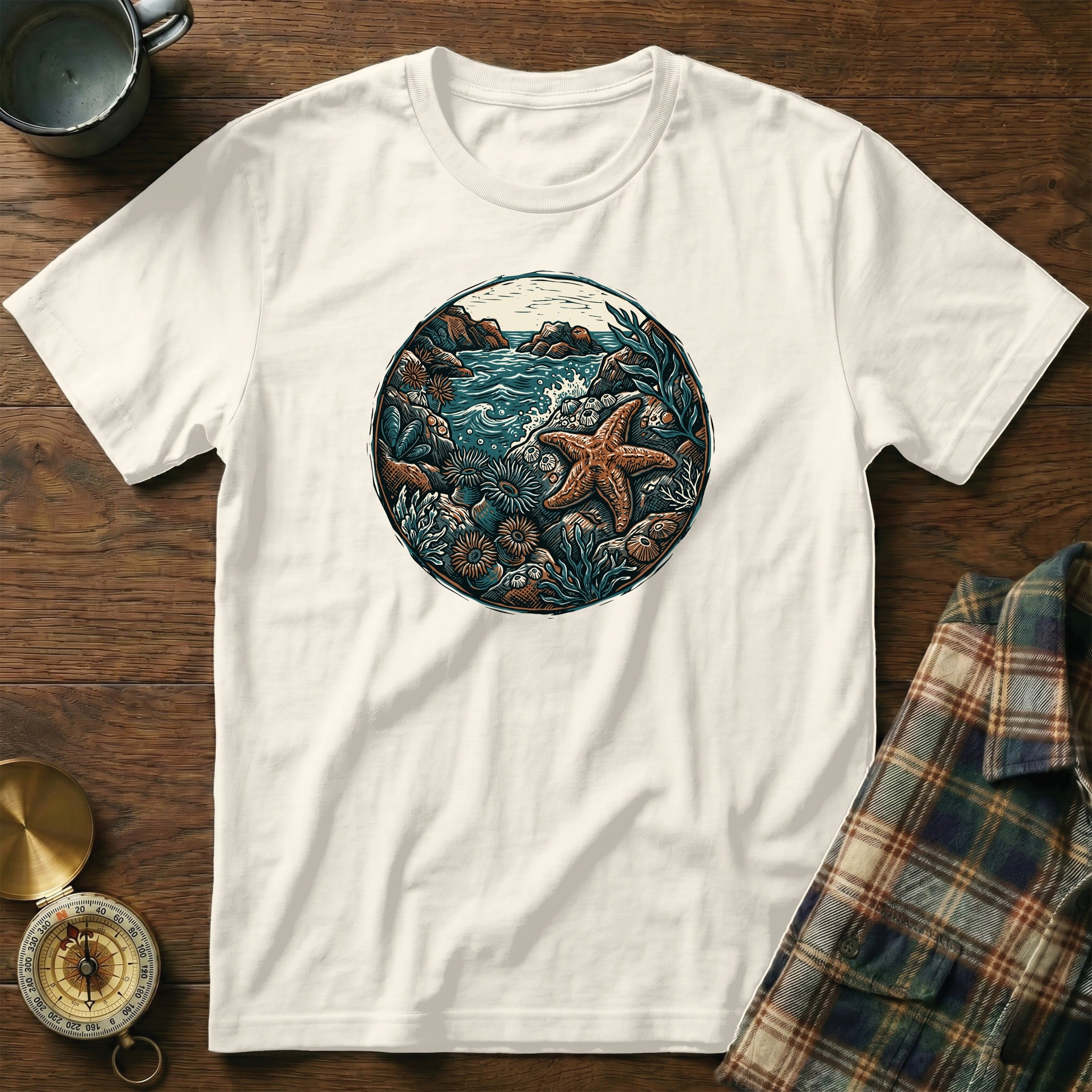 White t-shirt with circular ocean graphic featuring starfish, coral, and waves.