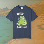 Navy Blue T-shirt Funny T-shirt graphic featuring a large, grumpy toad holding a to-go coffee cup. The cartoon is captioned with the quotes: "IT'S MONDAY AGAIN? I WASN'T EVEN FINISHED WITH MY SATURDAY YET.