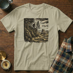 T-shirt with Bigfoot silhouette on cliff overlooking stormy ocean and rock.