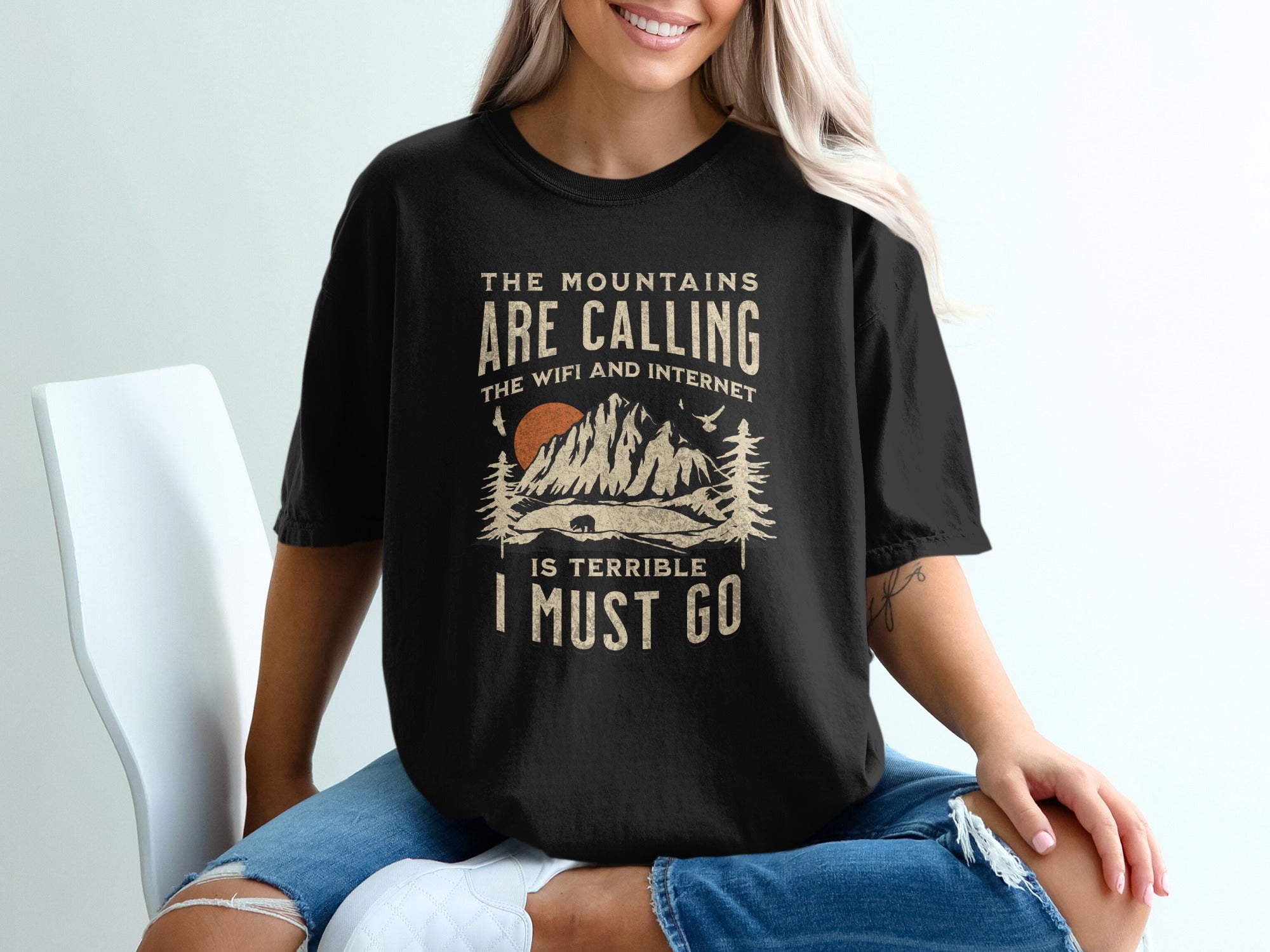 Black t-shirt with "The mountains are calling, the WiFi and internet is terrible I must go" graphic.