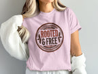 Pink t-shirt with a circular graphic that says "Rooted & Free"