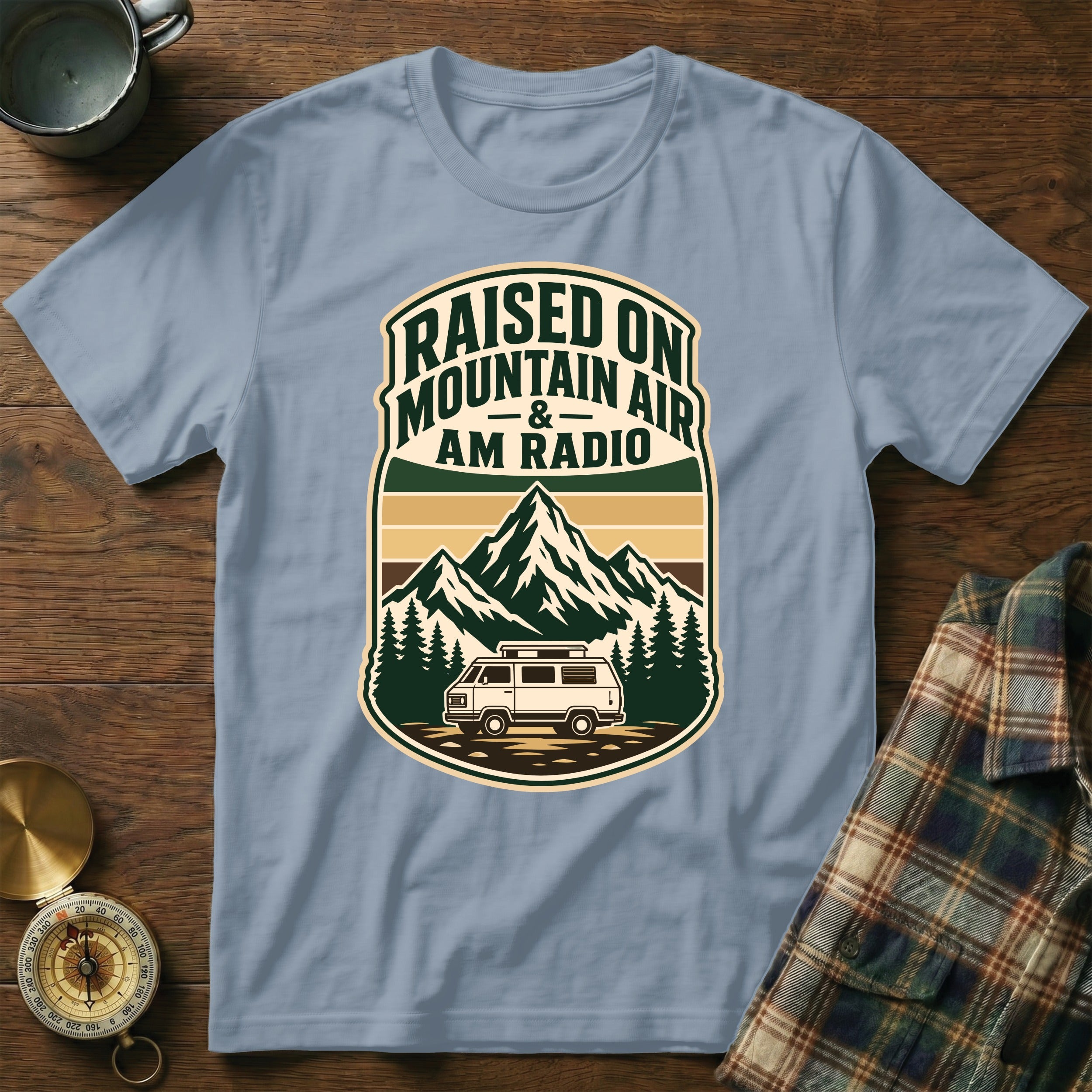 T-shirt graphic: "Raised On Mountain Air & AM Radio" with mountains and van.