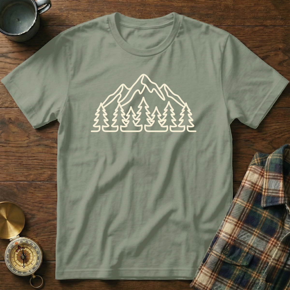 Sage green t-shirt with white mountain and tree graphic.
