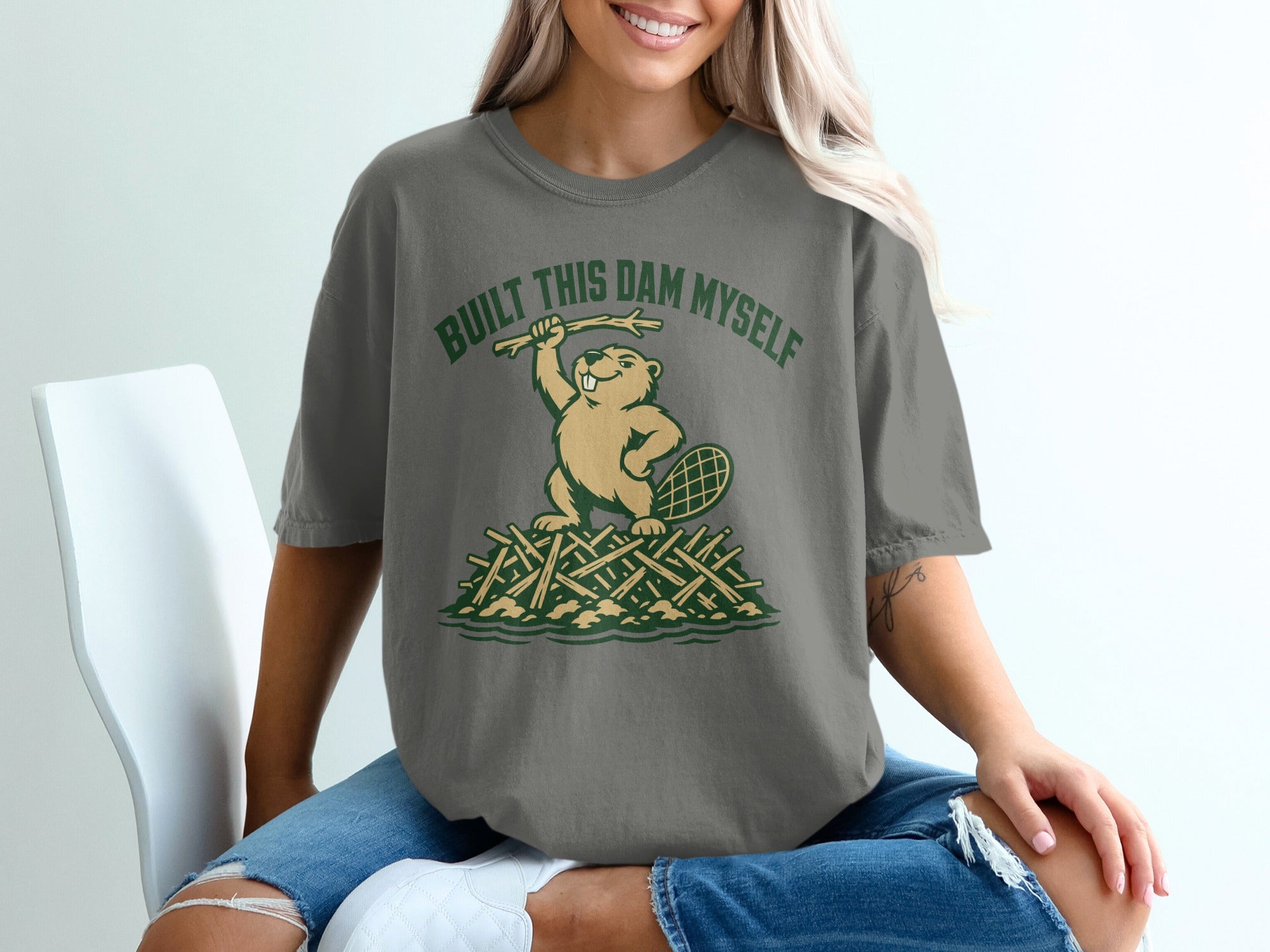 T-shirt with illustration of beaver holding stick above "BUILT THIS DAM MYSELF" text.