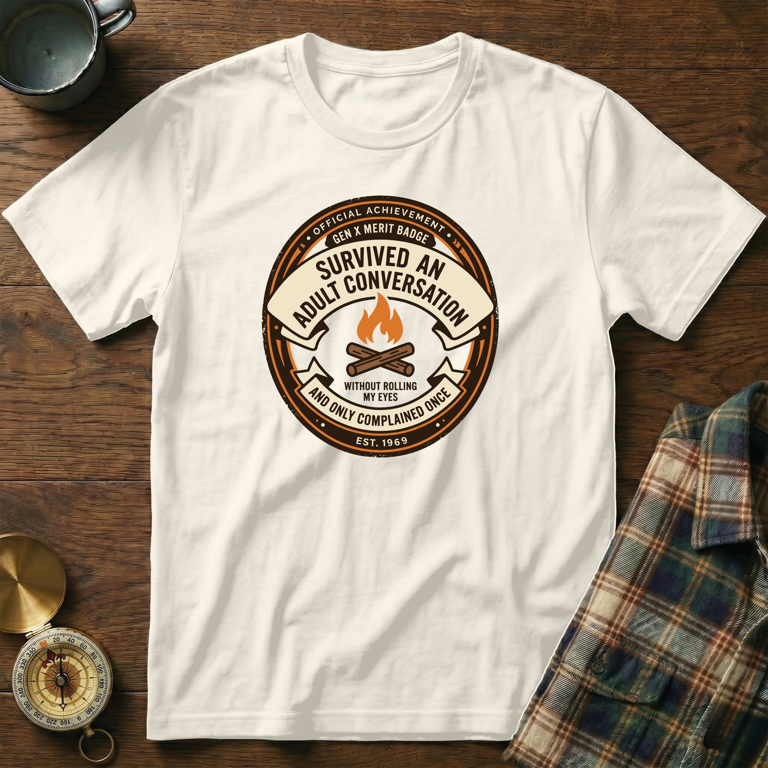 White t-shirt with a circular badge reading "Survived an adult conversation".