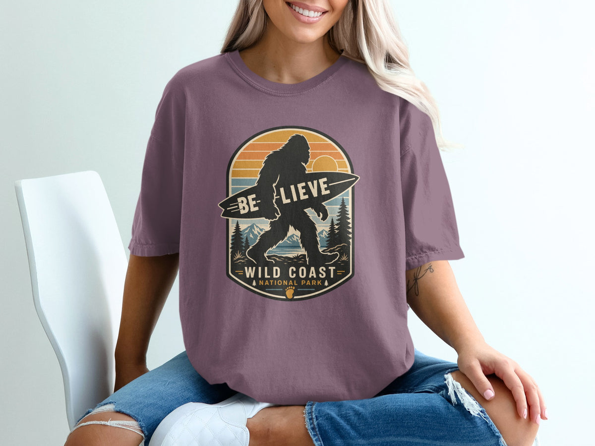 Bigfoot silhouette with surfboard, text "BE LIEVE WILD COAST NATIONAL PARK".