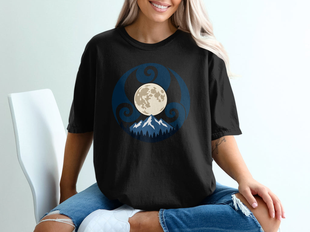 Black t-shirt with a circular design featuring a moon, mountains, and swirling patterns.