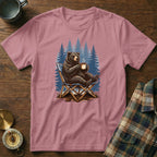 Pink t-shirt with a graphic of a bear sitting in a camp chair drinking coffee.