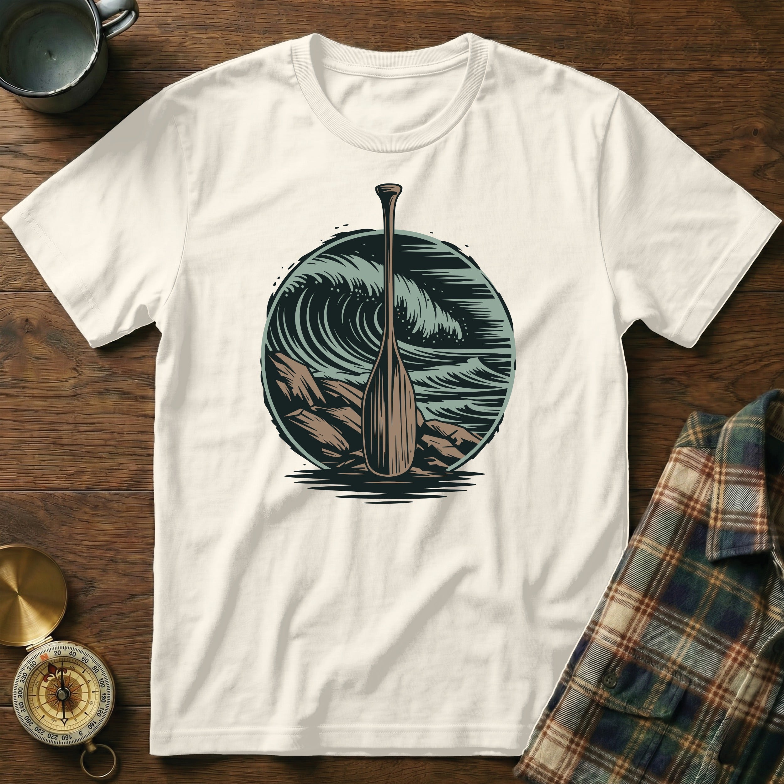 White t-shirt with a circular design of a paddle in front of ocean waves.