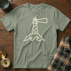 Sage green t-shirt with a cream outline drawing of a lighthouse on waves.