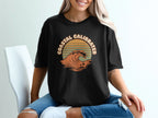 Black t-shirt with "COASTAL CALIBRATED" text and wavy sunset graphic.