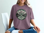 T-shirt with circular mountain and lake landscape graphic.