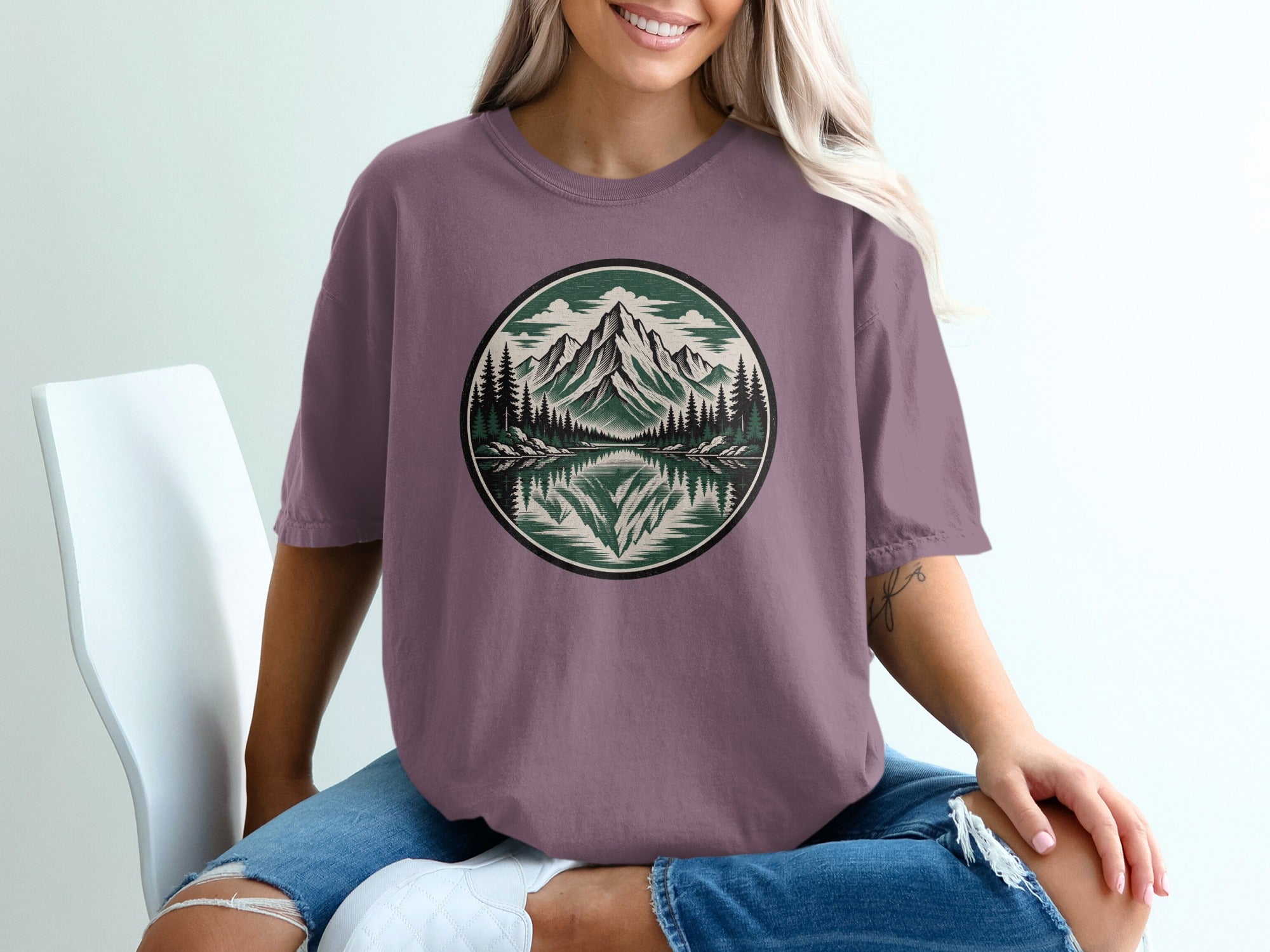 T-shirt with circular mountain and lake landscape graphic.