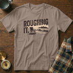 T-shirt with "ROUGHING IT." text, beach chair, ocean, and mountains.