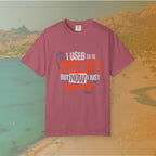 maroon Graphic T-shirt featuring the layered, distressed text: "I USED TO BE APATHETIC BUT NOW I JUST DON'T CARE," overlaid with halftone dot textures and boot print graphics.