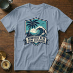Light blue t-shirt with shield graphic featuring palm tree, wave, and text "Nowhere Near Done Exploring".