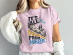 A light pink t-shirt worn by a person features the text It's All Downhill From Here and a graphic of a mountain goat sliding down a hill.