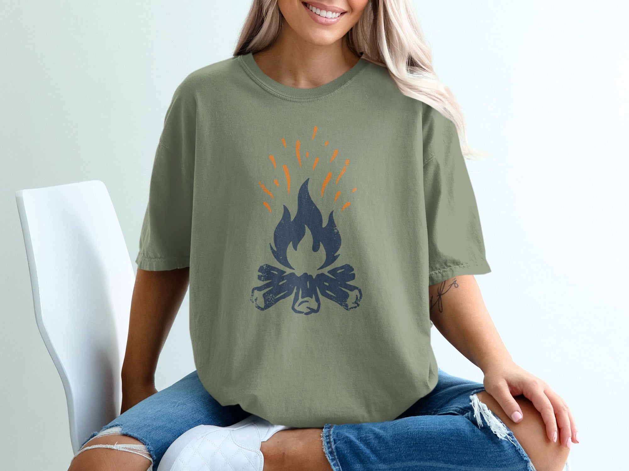 Green t-shirt with distressed campfire graphic.