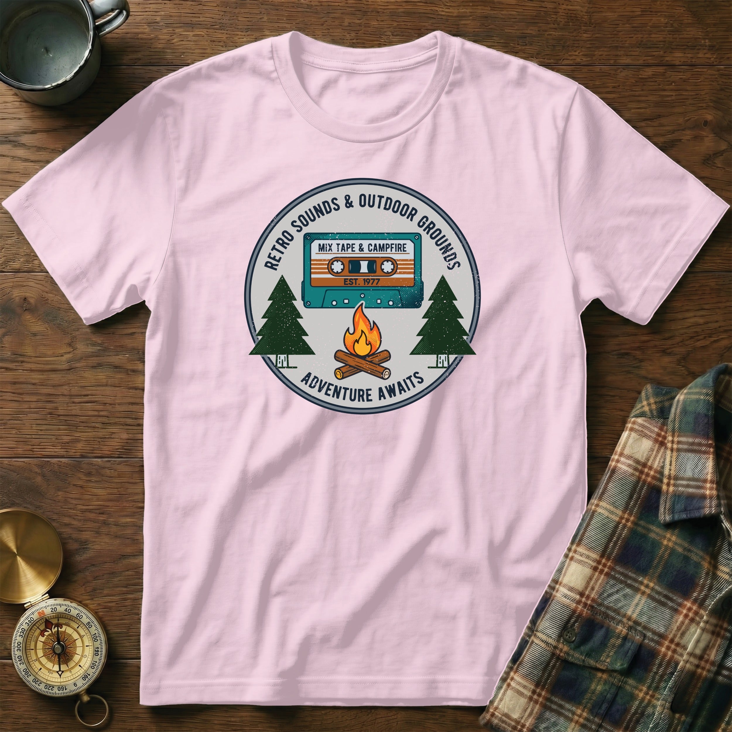 Pink t-shirt with retro mixtape and campfire graphic, text "Adventure Awaits".