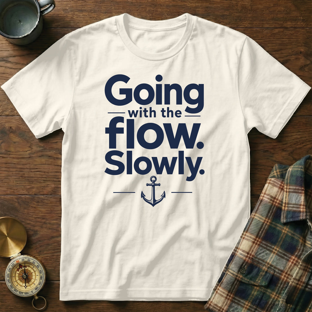 An off-white short-sleeved t-shirt features dark blue text reading "Going with the flow. Slowly." and an anchor graphic.