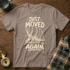 Hermit crab graphic on a taupe t-shirt with text "JUST MOVED AGAIN."