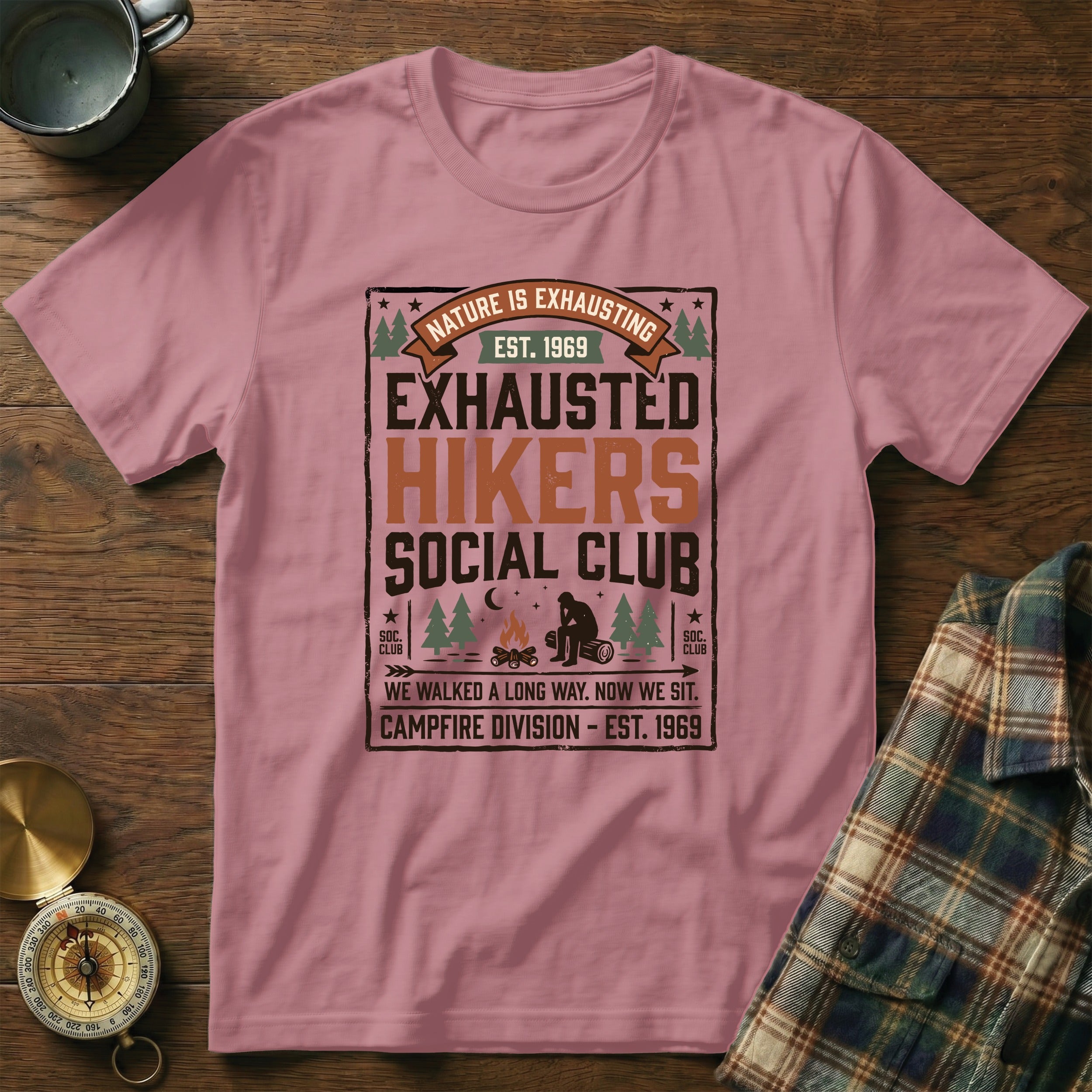 Pink t-shirt with "Nature is Exhausting" graphic and "Exhausted Hikers Social Club" text.