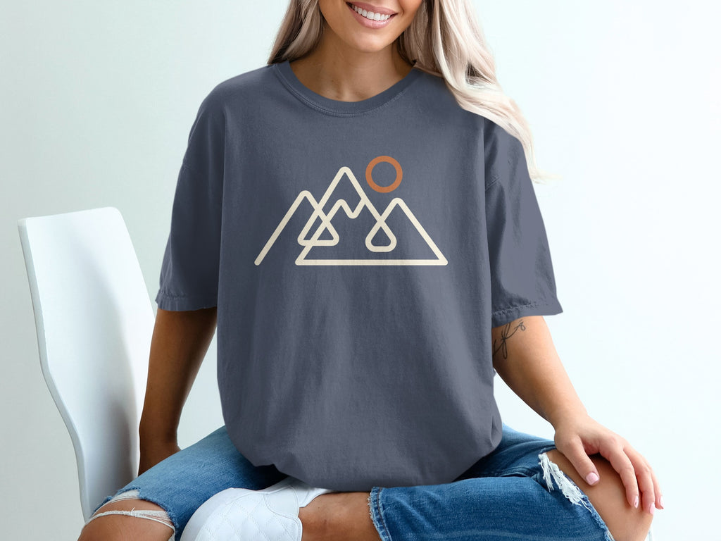 Dark grey t-shirt with a line art design of mountains and a sun.