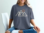 Dark grey t-shirt with a line art design of mountains and a sun.