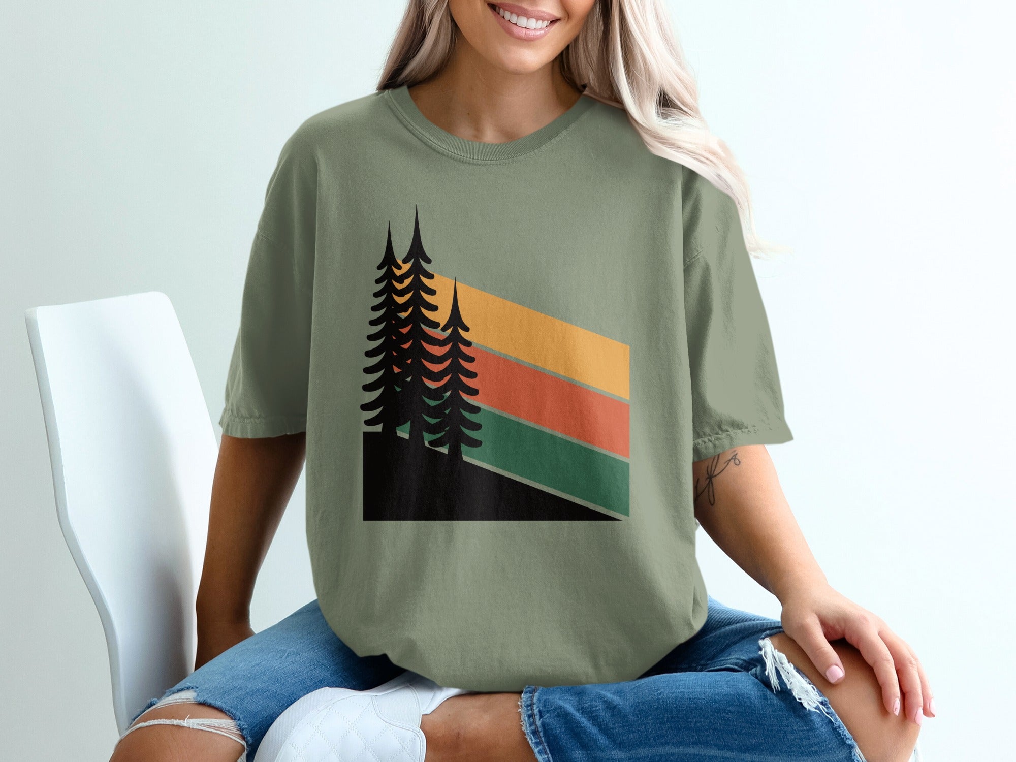 Green t-shirt with retro-style abstract pine trees and stripes graphic.