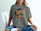 Circular desert landscape graphic on a grey t-shirt.