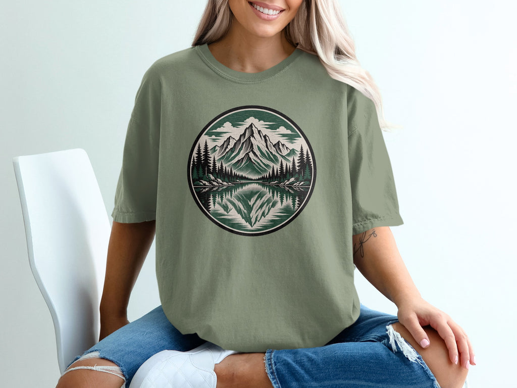 T-shirt with circular mountain, lake, and pine tree graphic.