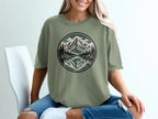 T-shirt with circular mountain, lake, and pine tree graphic.