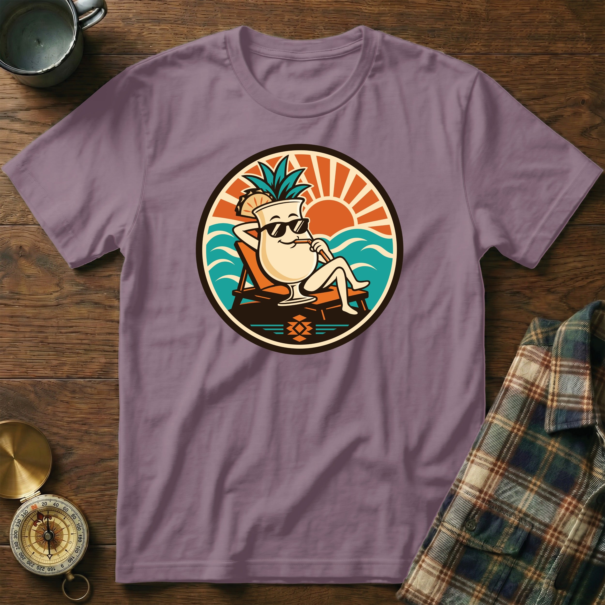 Purple t-shirt with a cartoon cocktail glass lounging on a beach.