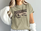 T-shirt with "Roughing It" text and a beach chair scene.
