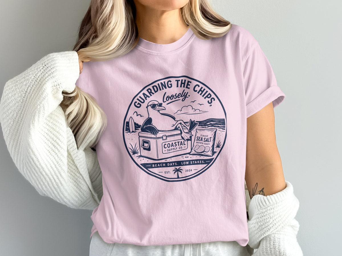 Pink t-shirt with "Guarding The Chips Loosely" graphic of a seagull and chips.