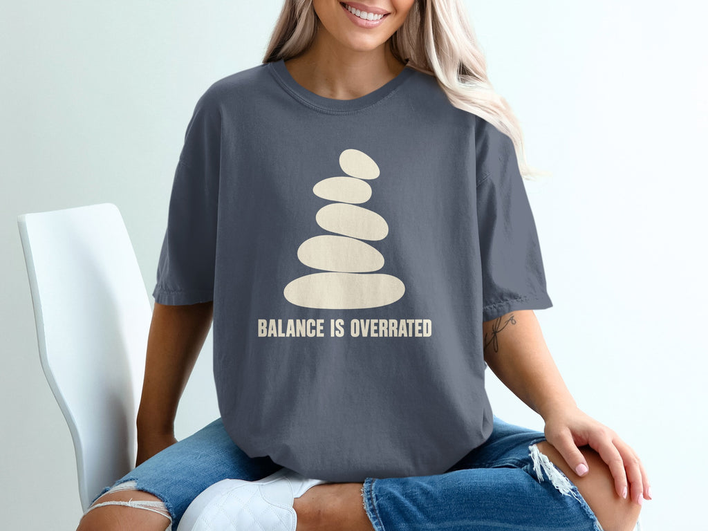 Gray t-shirt with stacked stones graphic and text "BALANCE IS OVERRATED".