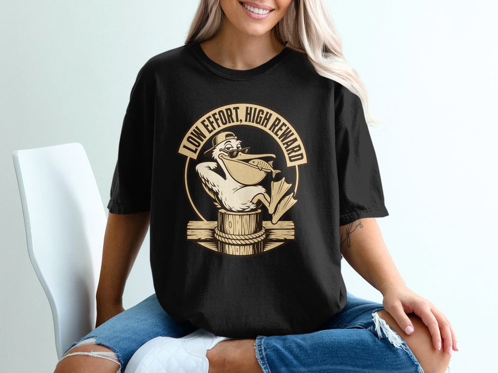 Black t-shirt with funny pelican graphic holding fish, text "Low Effort, High Reward".