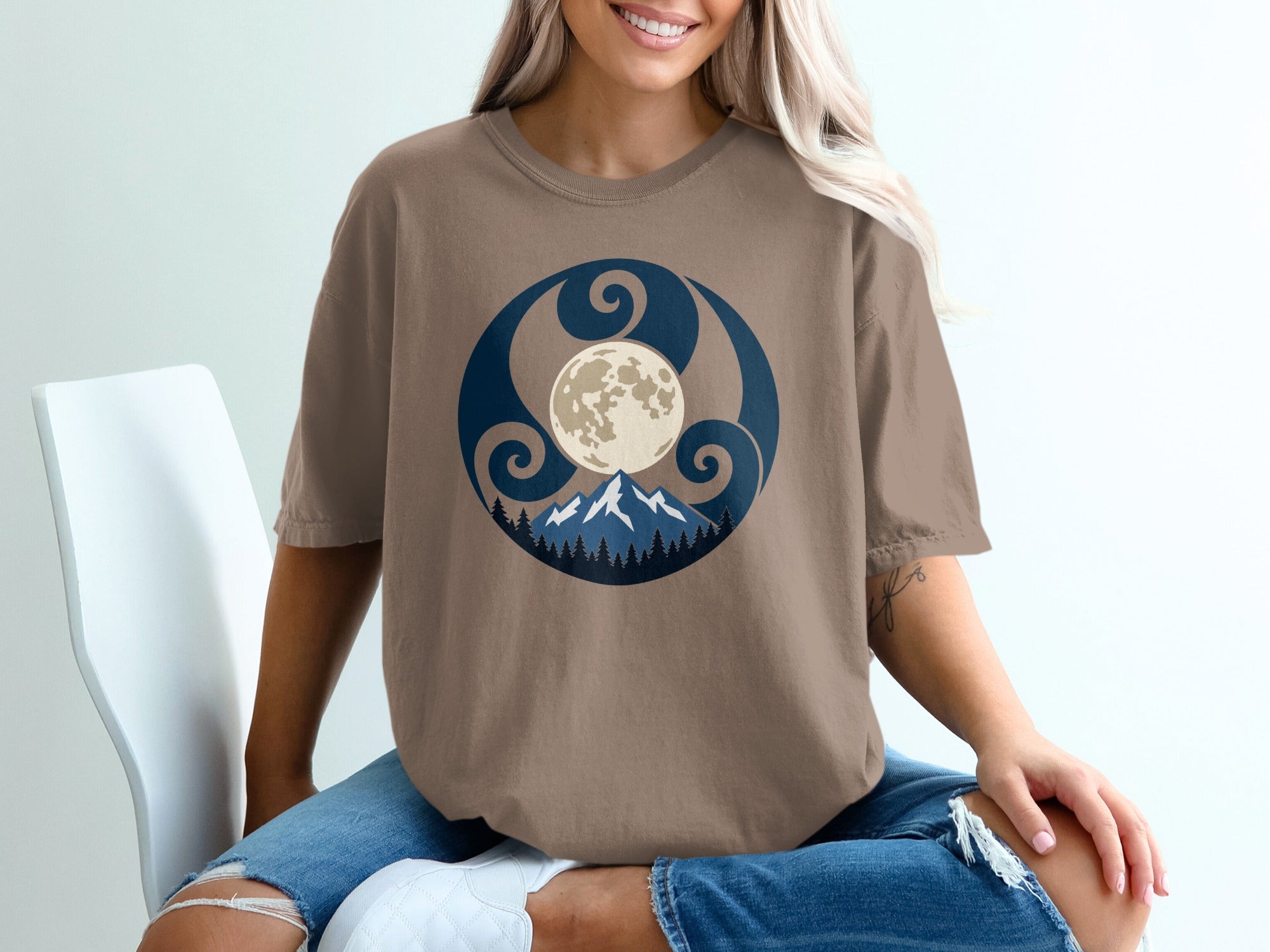 Brown t-shirt with circular graphic of moon, mountains, and trees.