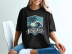 Black t-shirt with a beach scene graphic and text "Nowhere Near Done Exploring."