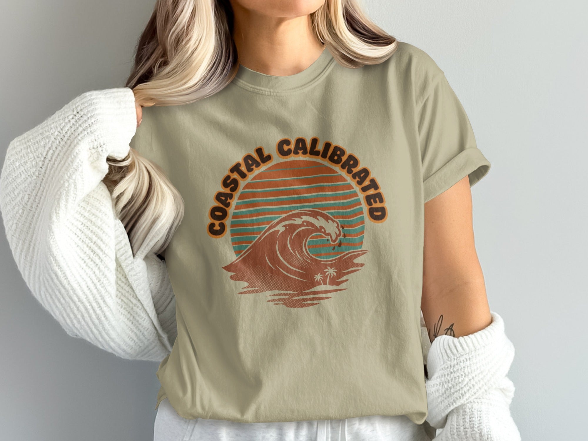 T-shirt with "Coastal Calibrated" text and a stylized wave and palm trees graphic.