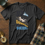 A black t-shirt features a graphic of a goat sliding down a mountain with the text It's All Downhill From Here.