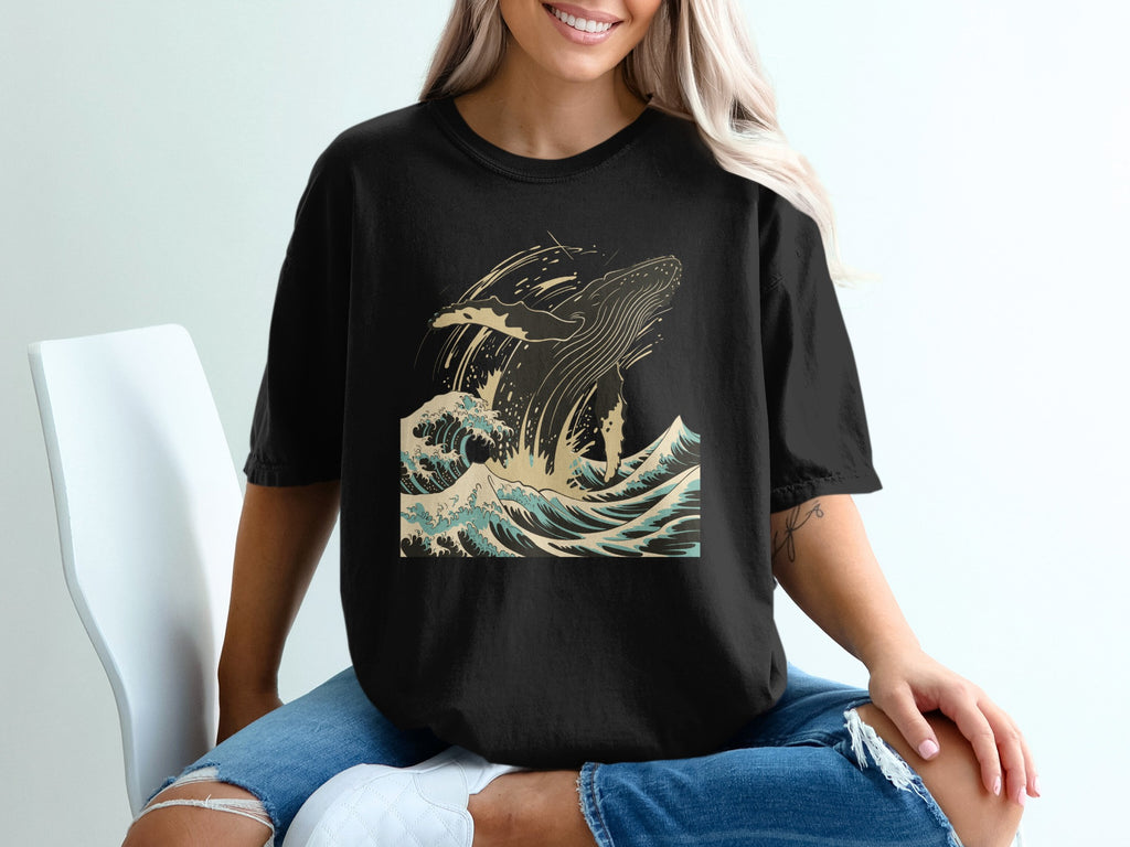 Black t-shirt with a jumping whale in crashing waves graphic.