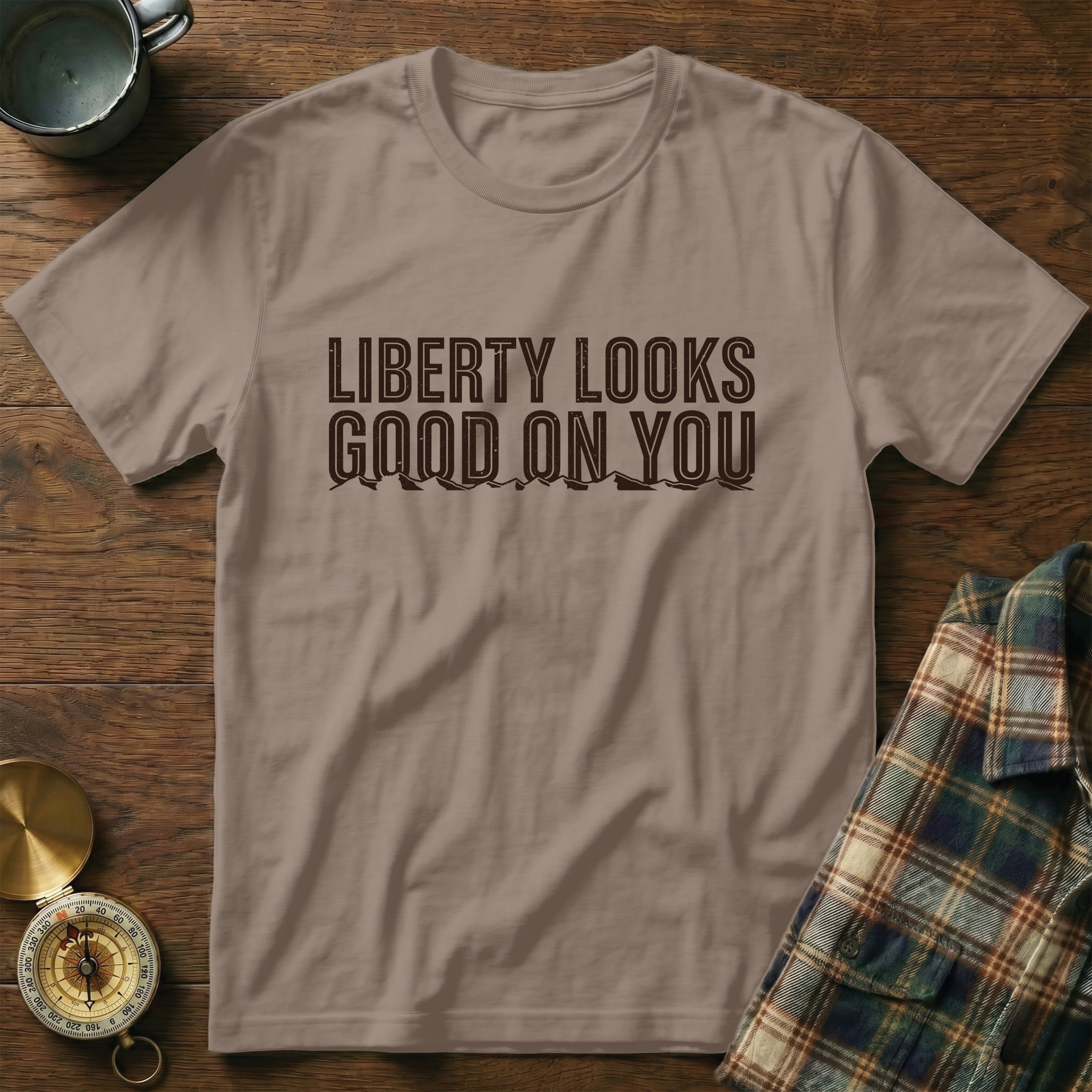 T-shirt with "Liberty Looks Good On You" printed in dark brown.
