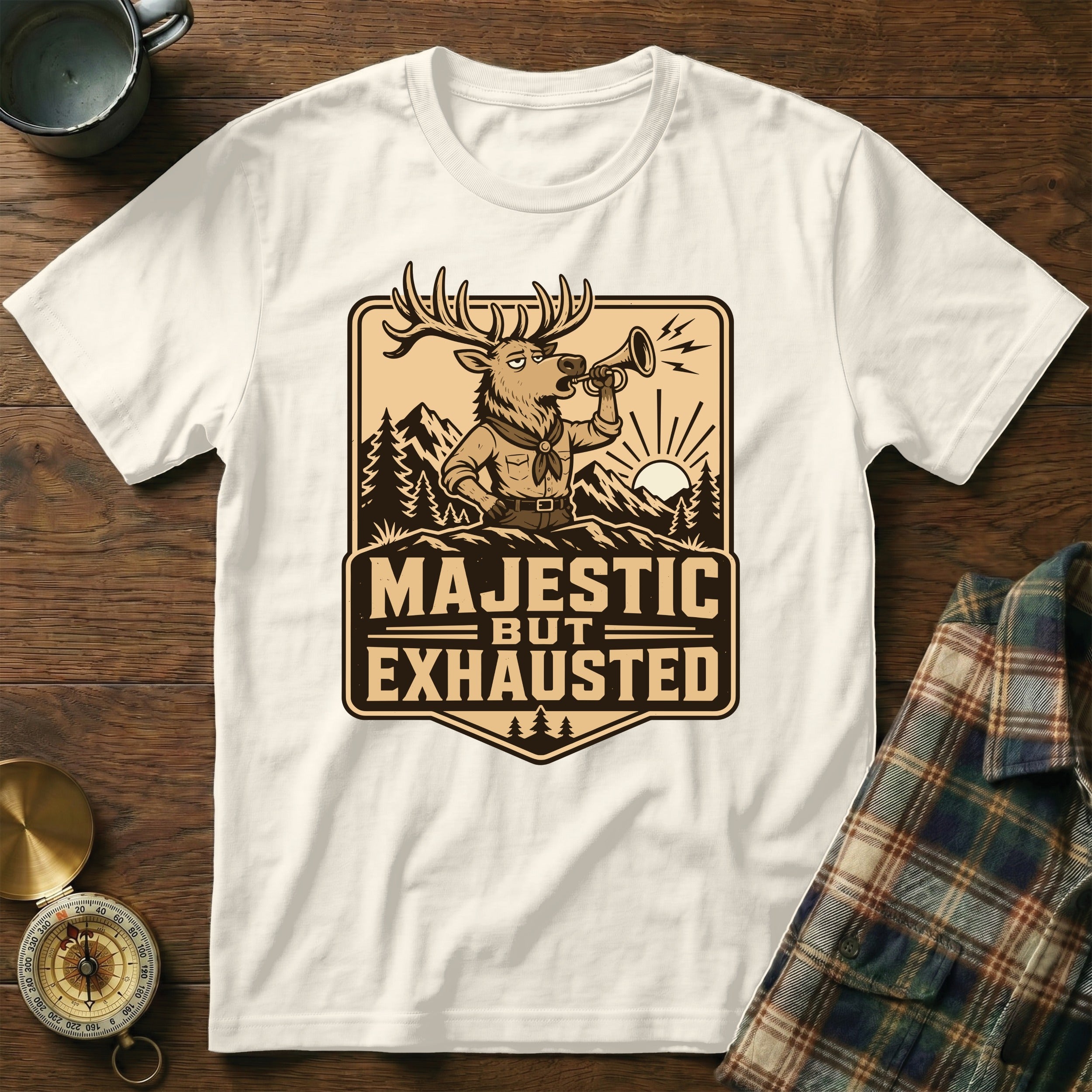 White t-shirt with graphic of a deer blowing a horn, text reads "MAJESTIC BUT EXHAUSTED".