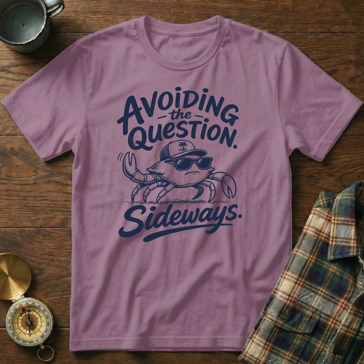 A mauve crewneck t-shirt featuring a cartoon crab wearing sunglasses and a cap, with the text Avoiding the Question Sideways.