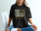 Black t-shirt with mountain graphic and text "BUILT FOR UNEVEN TERRAIN MENTAL & PHYSICAL".