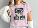 Pink t-shirt with "Snacks Packed?" flowchart and hiking humor.