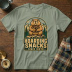 Groundhog hoarding snacks since birth graphic on a green t-shirt.
